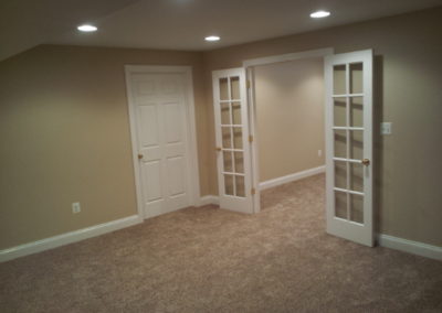 Room with beige carpet and walls, french doors (view 2).