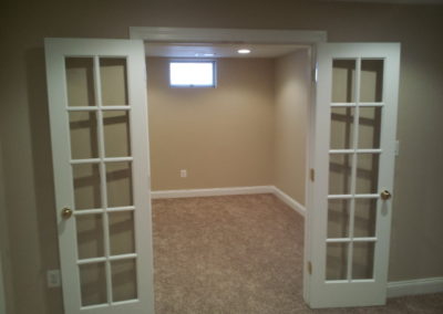 Room with beige carpet and walls, french doors (view 1).