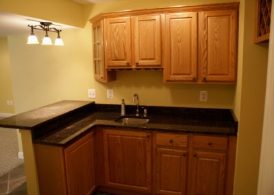 Basement Bar- yellow walls, black counter, wine rack (view 2).