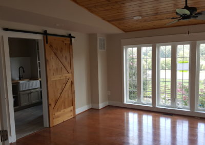 Interior room, wall of windows, sliding barn door, farm sink.