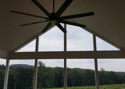 Covered deck with columns, upward view of ceiling fan (view 2).