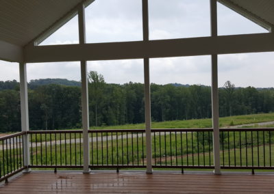 Covered deck with columns overlooking yard (view 1).