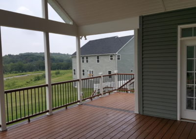 Covered deck with columns overlooking yard (view 3).