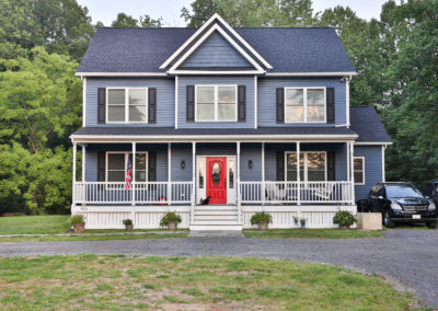 New Home- Blue siding and shutters, red front door, covered front porch
