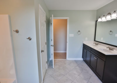 Guest Bathroom View 2- mint green walls, white tile floor, dual sinks