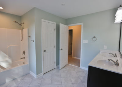 Guest Bathroom View 1- mint green walls, white tile floor, shower, dual sinks