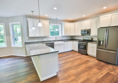 Kitchen- Wood floor, white cabinets, chrome appliances.