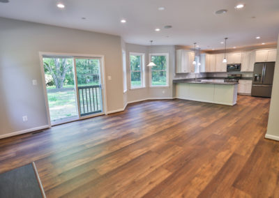 Finished Living Room- Wood floors, white kitchen, chrome appliances