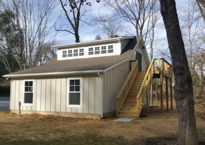 DeWall Garage View 3, rear exterior, white paneling, windows, stairs to deck.